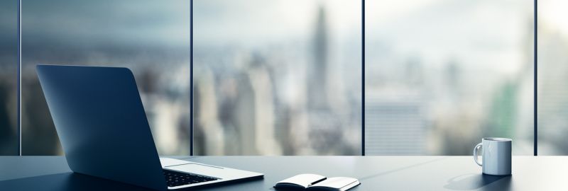 Overview of office winow with a laptop, a cup and a notebook 