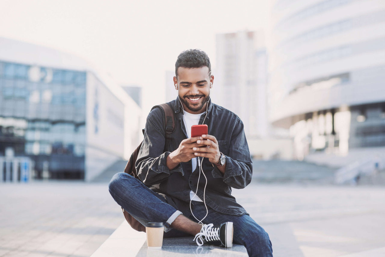 Hombre sonriendo escuchando música en el móvil
